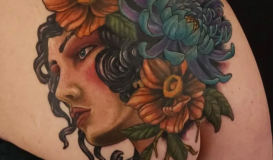 Neo-traditional tattoo of a woman's portrait with orange and teal flowers, by Adam Crane at Ministry Ink